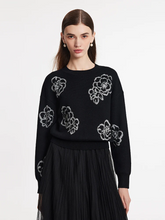 a lady in black  floral jacquard round neck sweater with black pleated skirt